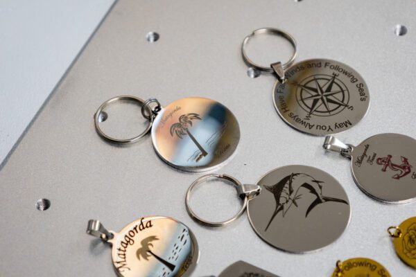 Island print designs engraved on keychain pendants